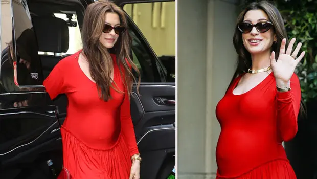 Anne Hathaway bir galada kırmızı halıda yürürken.