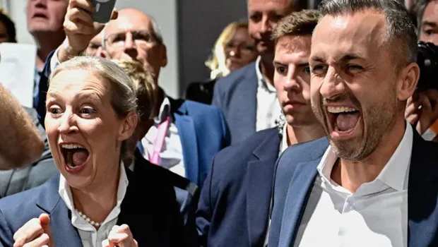 Almanya Saksonya-Anhalt eyalet meclisi binası önünde seçim sonuçlarını yansıtan bir görsel.