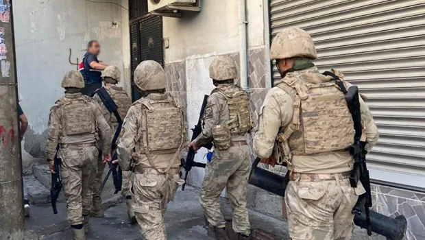 Adalet Bakanı Yılmaz Gürlek'in suçla mücadele operasyonlarını açıklarken çekilmiş bir fotoğrafı, arka planda ele geçirilen...