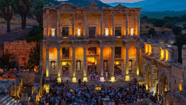 Efes Ören Yeri'nin gece ışıklandırması altında ziyaretçilerle dolu görüntüsü, gece müzeciliğinin başarısını simgeliyor.