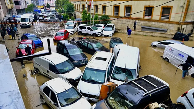 Şiddetli sağanak yağış ve fırtına bulutları altında şehir manzarası.