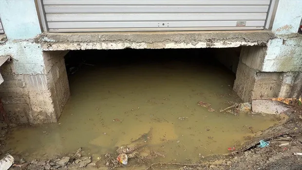 İstanbul'daki sel sonrası su basan bir binanın bodrum katında nemden zarar görmüş, paslanmış beton kolonları inceleyen bir...
