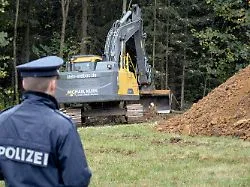 Polizei und Ermittler bei Grabungen in einem Waldstück, wo menschliche Überreste gefunden wurden, die mit dem Cold Case...