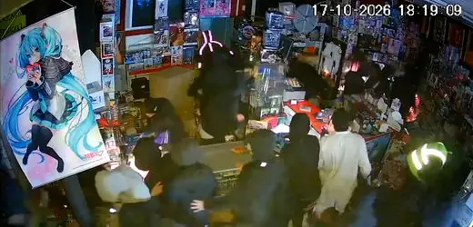 Ein beschädigter Laden in Paris nach Protesten, vor dem Menschen beim Aufräumen helfen.