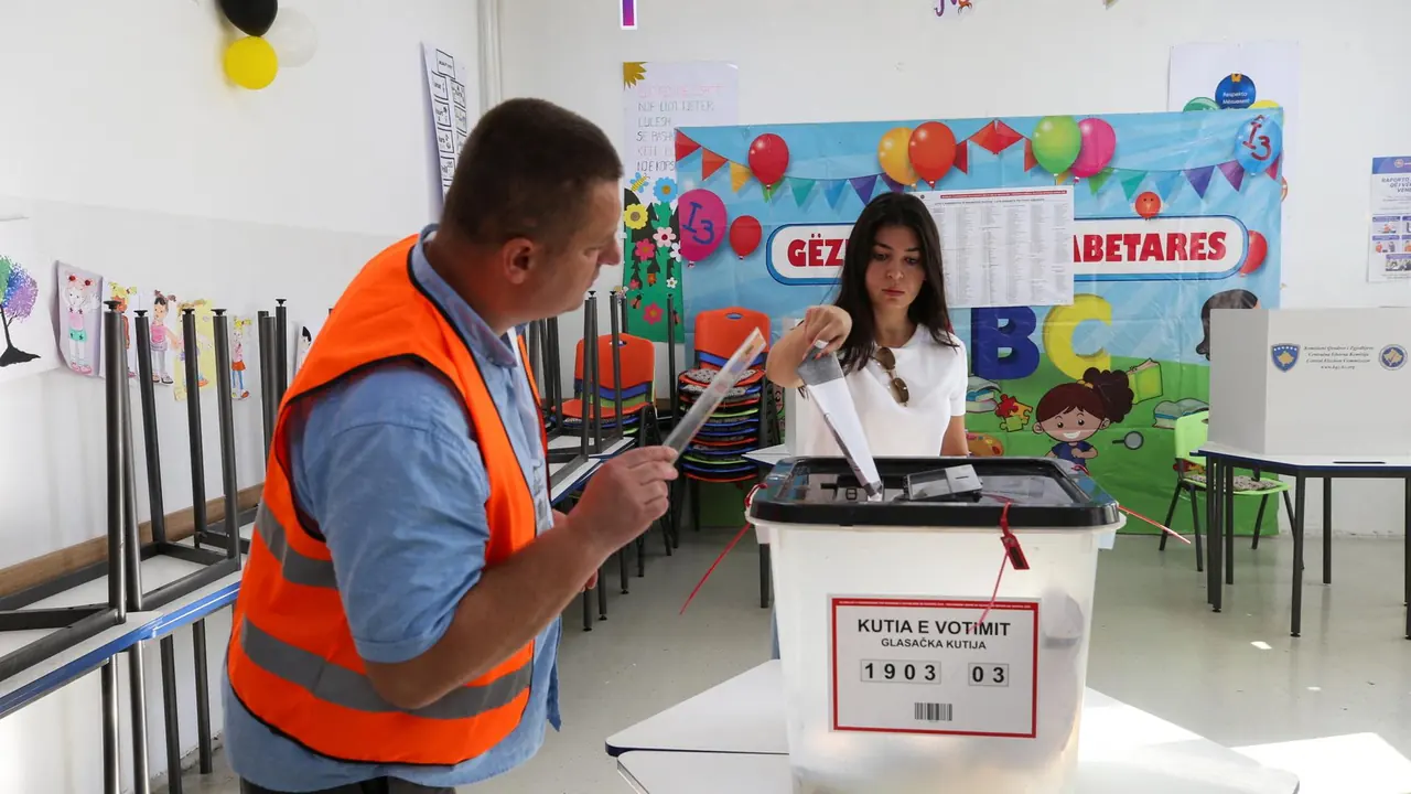 Eine Person wirft einen Stimmzettel in eine Wahlurne im Kosovo.