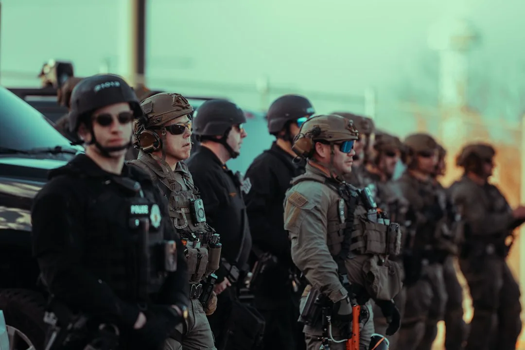 Uniformed federal agents standing at a residential doorstep conducting an inquiry.